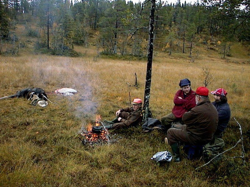 2004 Kvige Stakkjolen_5.jpg - Svartkjelen henger over bålet, og Jostein, Bernt, Kåre og Frode venter på kaffen